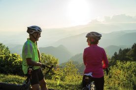 A Male and Female couple ride bikes on the Blue Ridge Parkway at Day