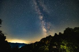 This is a landscape photograph of the night sky with the Milky Way over rural Bryson City during summer in the Great Smoky Mountains North Carolina.