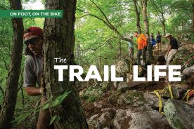 Thomas Jenkins (lovin’ on the tree) has been a part of building or protecting some 200 miles of trail.