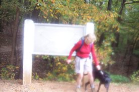 The Greatest Day Hiker of Them All, with puppy, seen through a somewhat smeared camera lens.