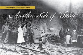 The caption that circulates with this photo reads: “Eight members of the Ingram family with their turnip-style moonshine still. Ida Ingram Nunley is the woman sitting and holding a shotgun.”