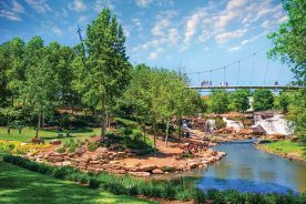 The 345-foot Liberty Bridge sits in the heart of downtown Greenville, spanning the Reedy River as it overlooks an urban waterfall and the rolling gardens of Falls Park on the Reedy River.