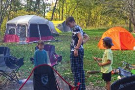 Andy, Tyler and Watson give morning attention to the campfire.