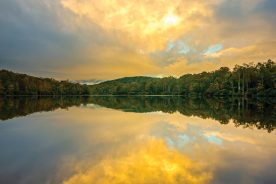 Early morning light reflects along Price Lake as clouds engulf Grandfather Mountain along the Blue Ridge Parkway in western North Carolina.